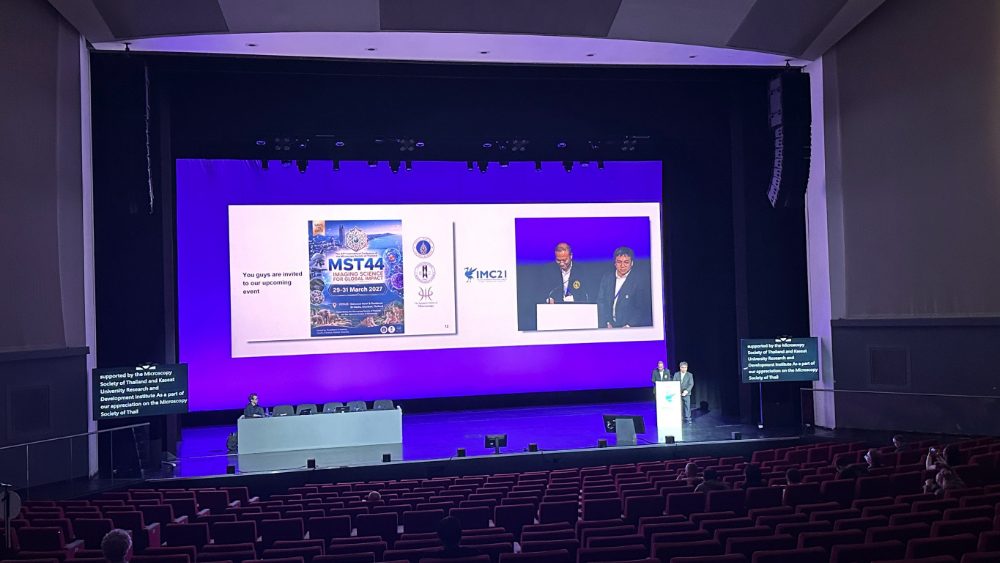 An MST44 save-the-date slide shown on the main IMC21 stage screen alongside the IMC21 logo